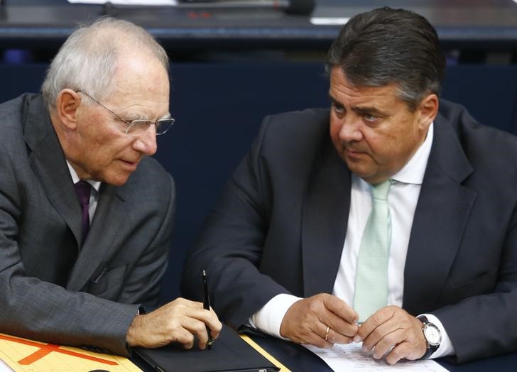 © Reuters. German Finance Minister Schaeuble speaks with Economy Minister Gabriel during the session of the German lower house of parliament Bundestag in Berlin