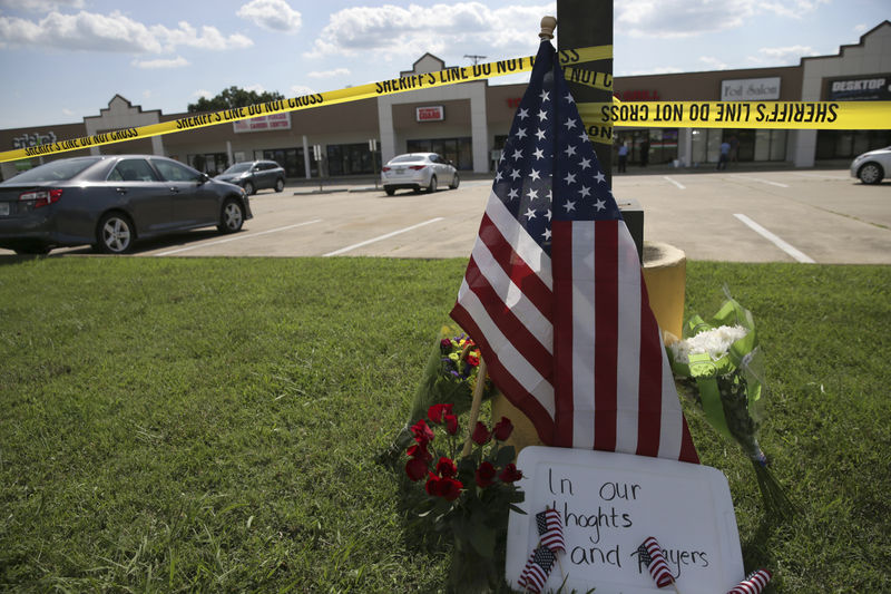 © Reuters. Handout of police tape and a makeshift memorial sit on the lawn in front of an Armed Forces Career Center in this handout photo provided by the U.S. Navy, where earlier in the day a gunman opened fire, injuring one U.S. Marine in Chattanooga