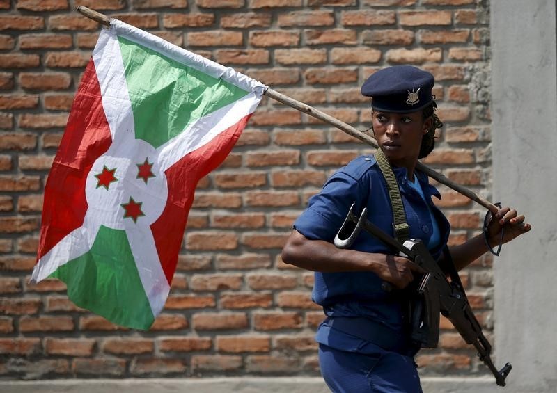 © Reuters. A policewoman carries a Burundi flag during a protest against President Pierre Nkurunziza's decision to run for a third term in Bujumbura