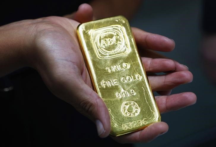 © Reuters. A woman holds a one-kilogram gold bar at the headquarters of the Australian Bullion Company in Sydney