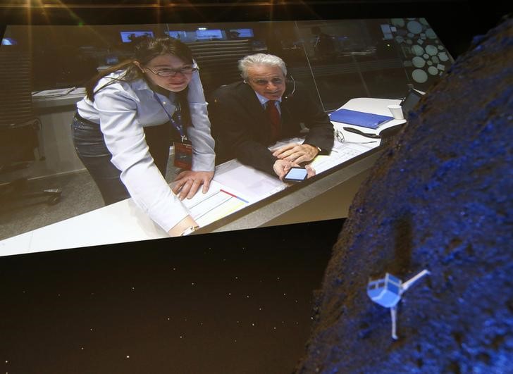 © Reuters. Pesquisadores europeus vistos em vídeo atrás de modelo da sonda Philae no cometa 67P/ Churyumov-Gerasimenko