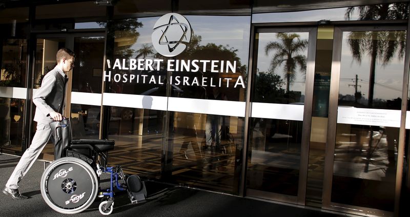 © Reuters. Man pushes wheelchair at entrance of Albert Einstein Hospital, where Pele was hospitalized since last week in Sao Paulo 