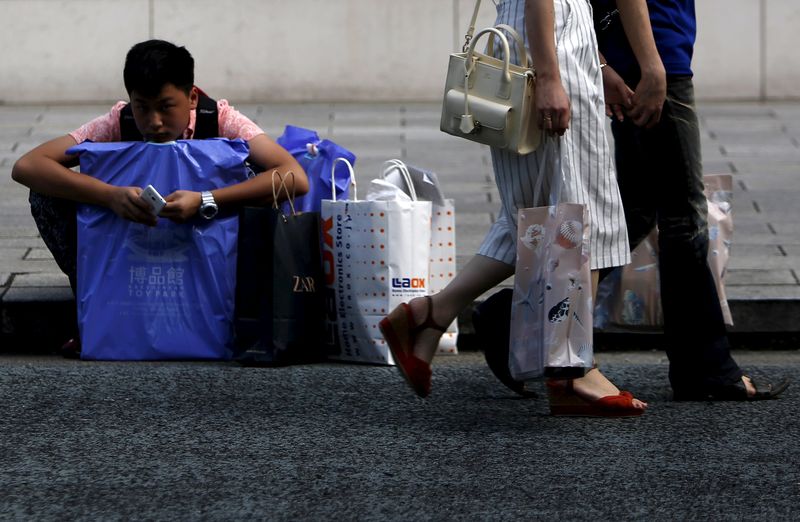 © Reuters. A shopper from China waits for his family as people walk past at Tokyo's Ginza shopping district in Japan