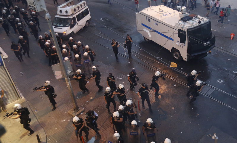 © Reuters. Riot poolice chase demonstrators during a protest in central Istanbul, Turkey