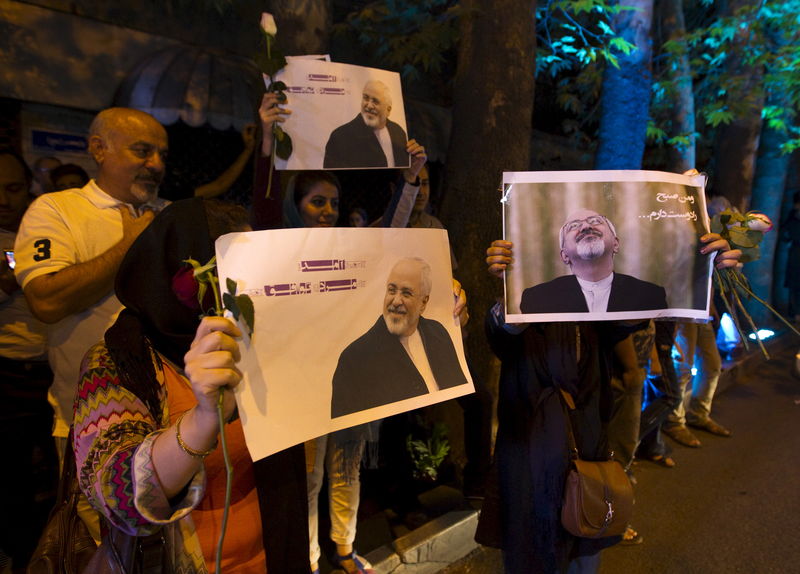 © Reuters. Iranians hold pictures of Iranian Foreign Minister Mohammad Javad Zarif as they celebrate in the street following a nuclear deal with major powers, in Tehran