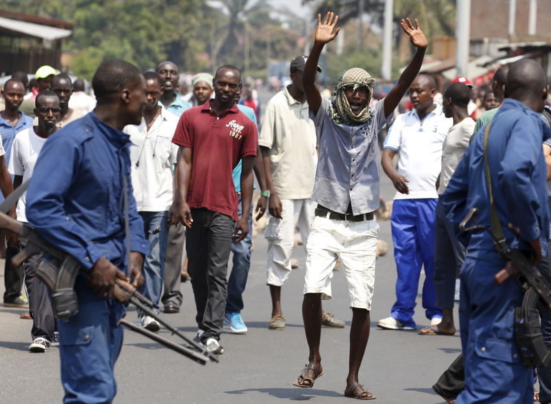 © Reuters. Manifestantes debocham da polícia em ruas de Bujumbura no dia da eleição presidencial no Burundi