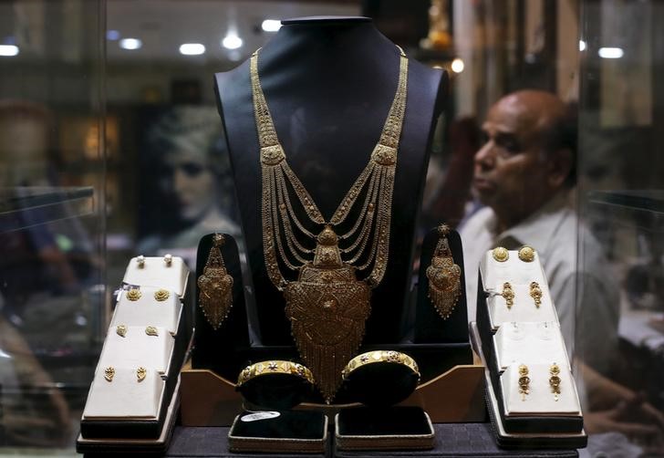 © Reuters. A gold necklace is displayed as a salesman waits for customers inside a jewelry showroom in the old quarters of Delhi