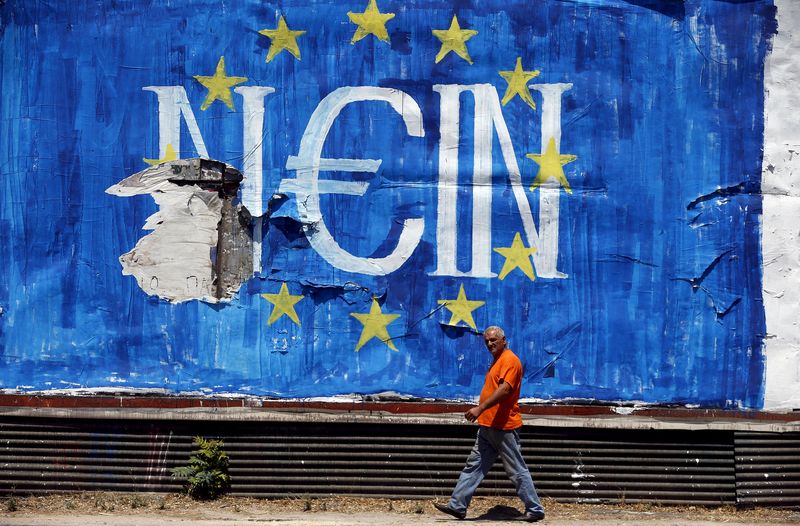 © Reuters. A man walks past graffiti in Athens, Greece 