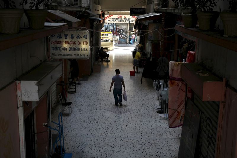 © Reuters. A man walks through a shopping arcade in central Athens