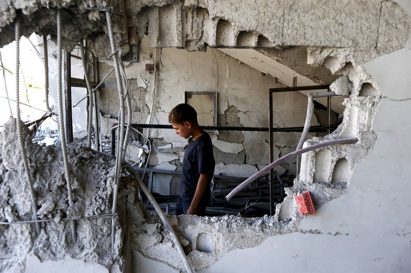 © Reuters. A child inspects site hit by what activists said was airstrike by forces loyal to Asaad at Arbin town in Damascus countryside, Syria