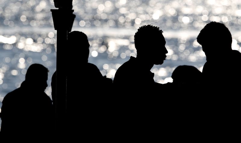 © Reuters. Messina, migranti in attesa di sbarcare da una nave di soccorso