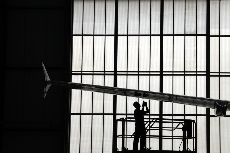 © Reuters. A worker uses a drill to screw bolts into the wing of an A320 plane that is under construction at the Airbus factory located in the northern Chinese city of Tianjin