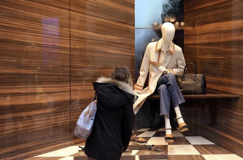 © Reuters. Una donna di fronte ad una vetrina a Milano 