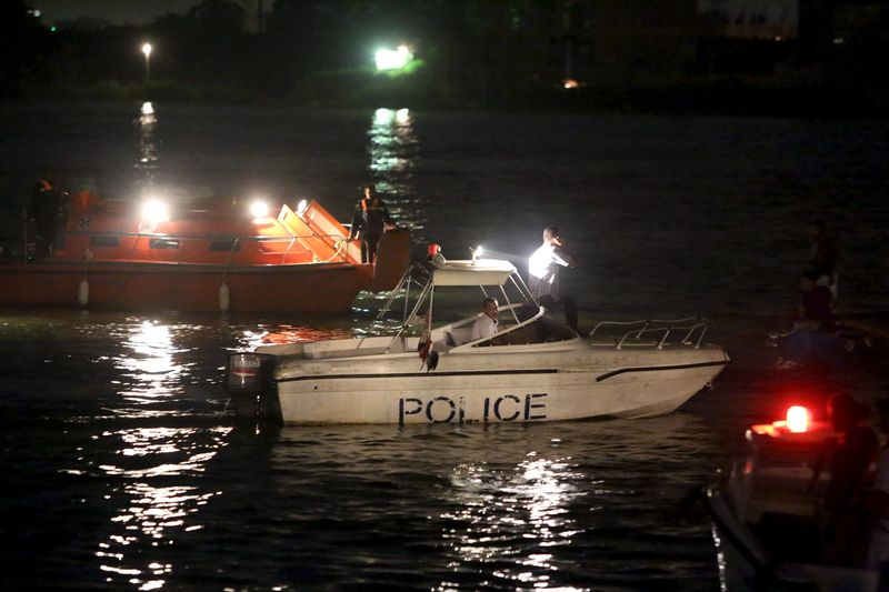 © Reuters. Police boats search for victims of a boat accident on the River Nile in the Warraq area of Giza, Egypt