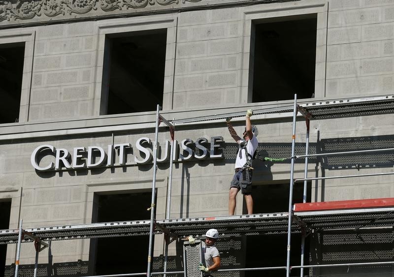 © Reuters. Construction workers stand on a scaffolding beside the logo of Swiss bank Credit Suisse at a construction site in Zurich