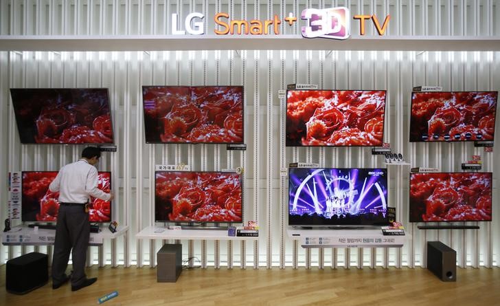 © Reuters. An employee works in front of LG Electronics' organic light-emitting diode (OLED) TV sets, which are made with LG Display flat screens, at its store in Seoul