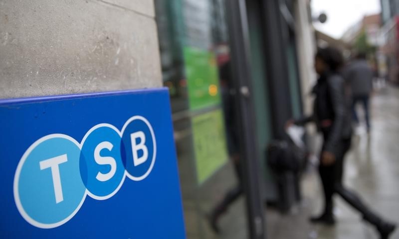 © Reuters. A woman wlalks into a branch of TSB bank in London