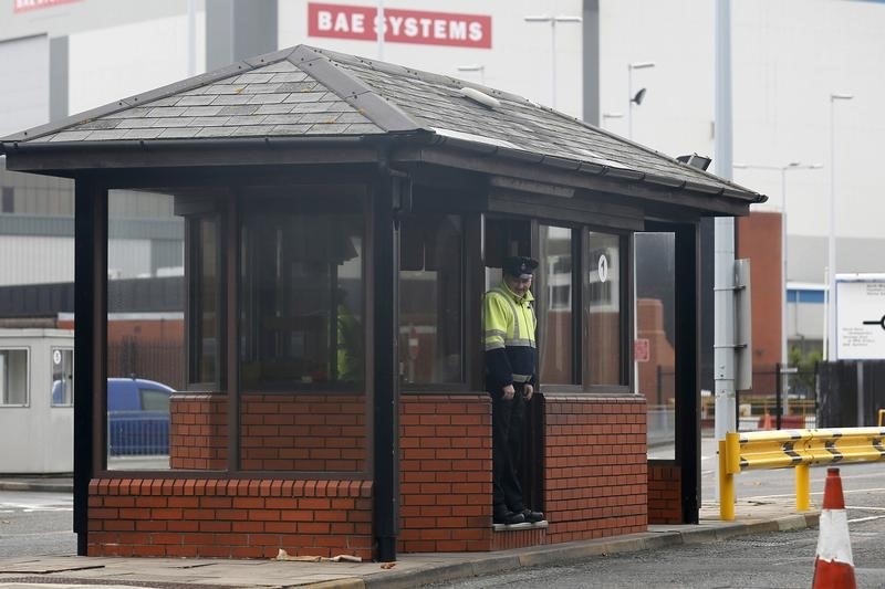 © Reuters. A security guard stands at the entrance to the naval dockyards, where BAE Systems is located, in Portsmouth
