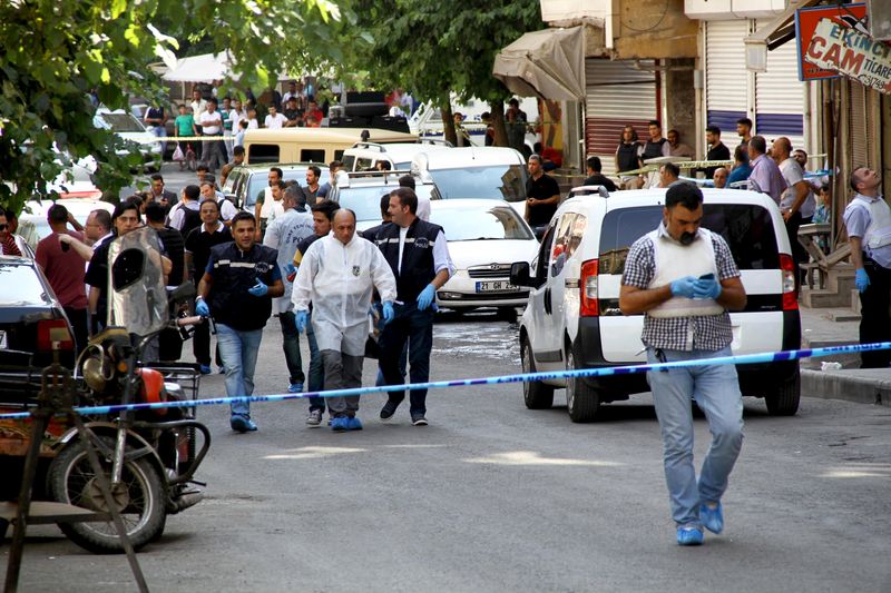 © Reuters. Police forensic experts examine the street following an attack on police officers in Diyarbakir