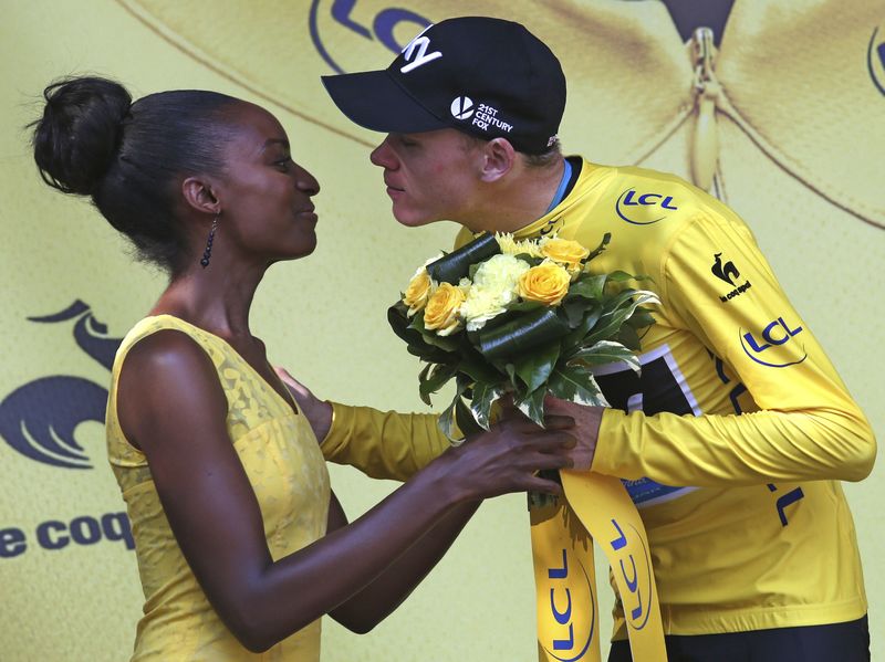 © Reuters. Team Sky rider Chris Froome of Britain, race leader's yellow jersey, kisses an hostess on the podium after the 18th stage of the Tour de France cycling race