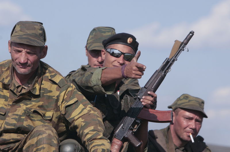 © Reuters. Members of the self-proclaimed Donetsk People's Republic forces sit on an armored vehicle on the roadside near the site of the Malaysia Airlines flight MH17 plane crash outside the village of Hrabove