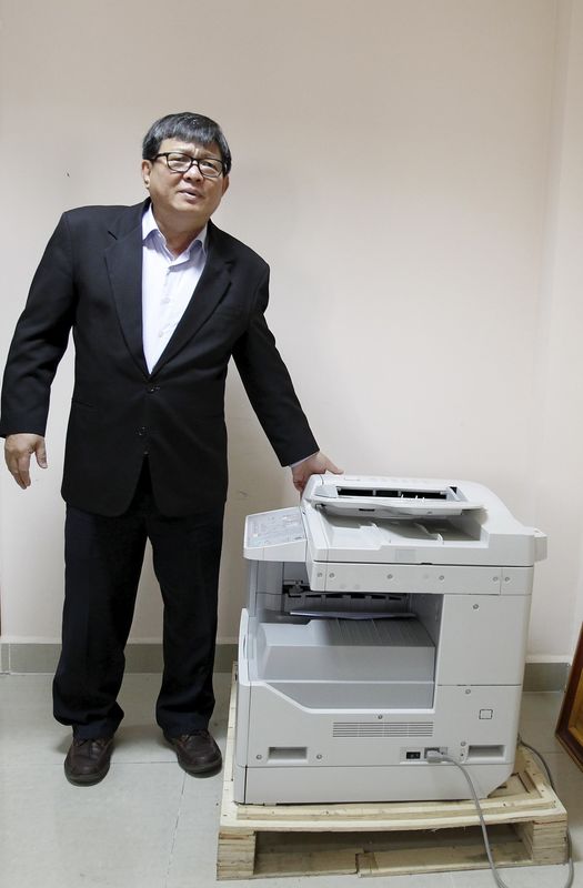 © Reuters. Son Chhay, a lawmaker of Cambodia National Rescue Party (CNRP), stands next to a copy machine during an interview with Reuters at the Cambodian National Assembly in Phnom Penh