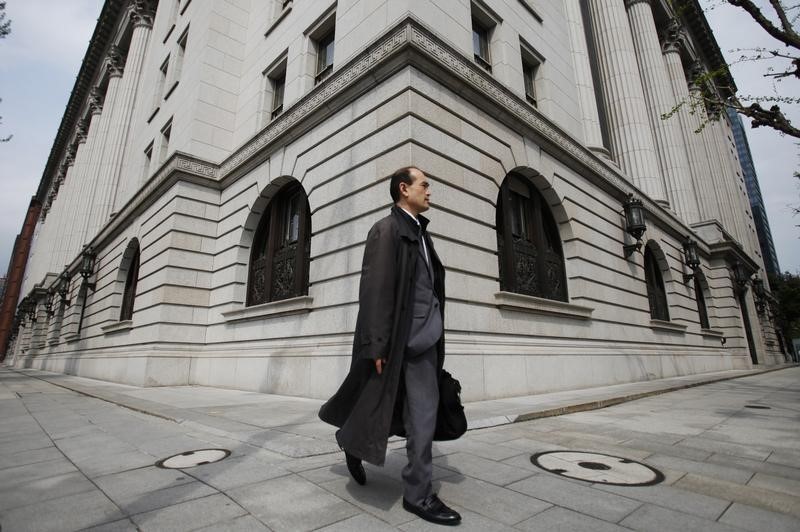 © Reuters. A man walks past insurance company Meiji Yasuda Life in Tokyo