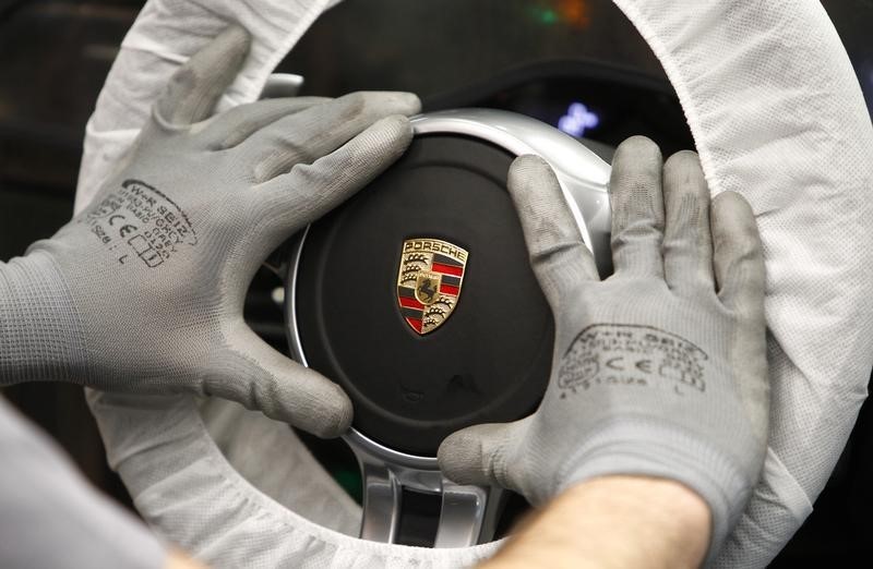 © Reuters. Un lavoratore assembla una ruota della nuova Porsche 911 alla fabbrica di Stuttgart-Zuffenhausen, in Germania.