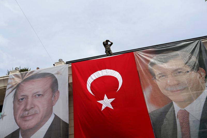 © Reuters. Immagini del presidente turco Tayyip Erdogan e il primo ministro Ahmet Davutoglu su una bandiera a Istanbul.