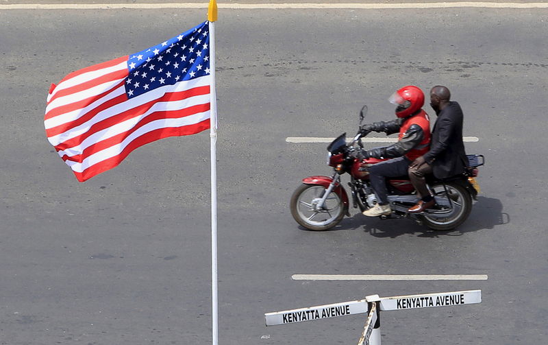 © Reuters. Moto passa pela bandeira dos EUA em avenida de Nairóbi antes da visita do presidente Barack Obama ao Quênia