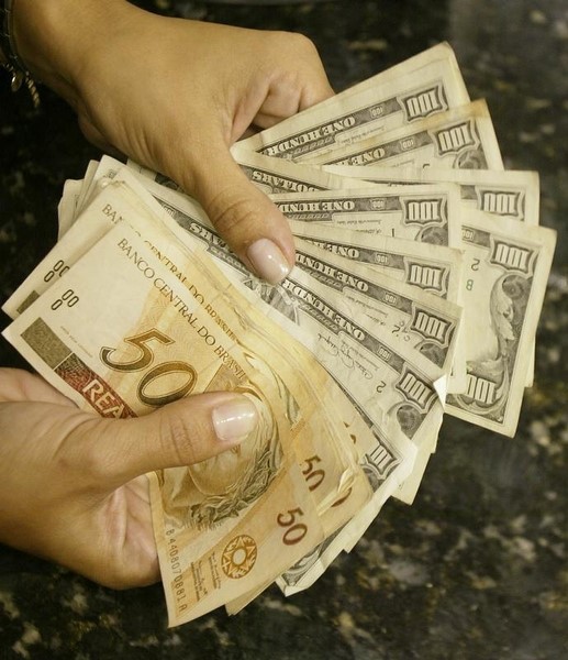 © Reuters. Mulher troca reais por dólares em casa de câmbio no Rio de Janeiro