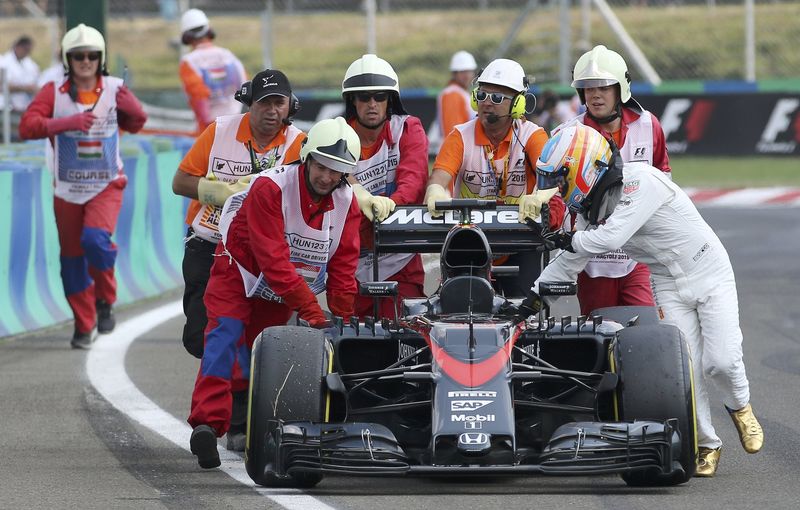 © Reuters. La imagen de Alonso empujando su McLaren, un reflejo de la temporada 