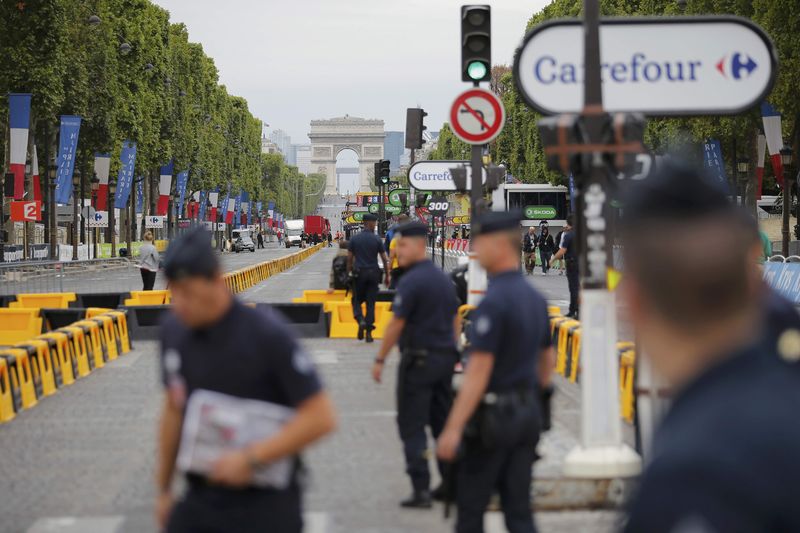 © Reuters. French police secure the Champs Elysees after a car drove through barriers nearby set up for the final stage of the Tour de France in Paris