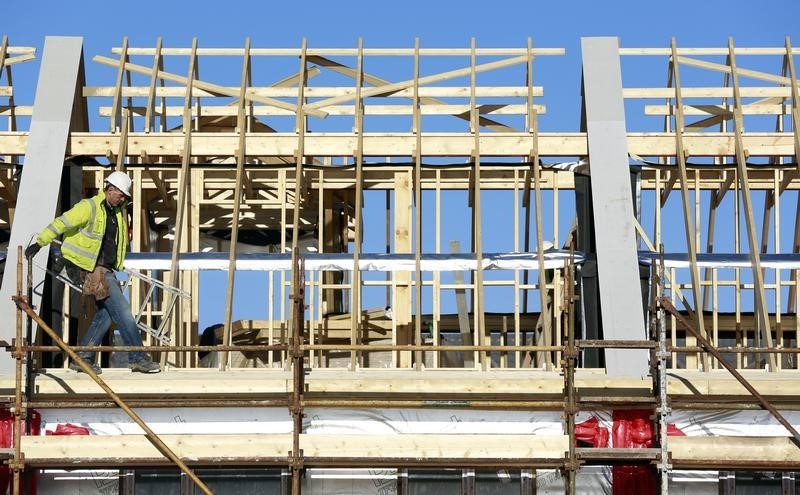 © Reuters. A construction worker carries stepladders at 'The Cedars' housing development site in Swords