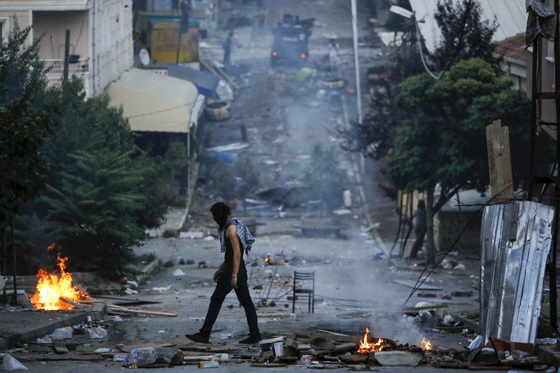 © Reuters. A far left-wing protester walks during clashes with riot police in Istanbul's Gazi neighborhood