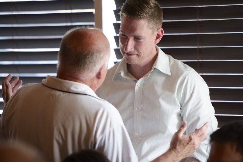 © Reuters. American for Prosperity Alaska State Director Jeremy Price speaks with an attendee during an organizing meeting in a restaurant in Anchorage