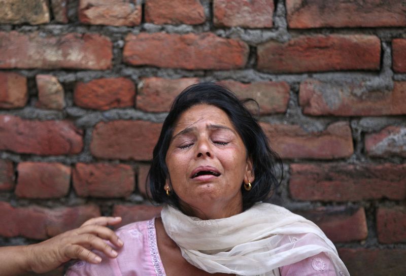 © Reuters. Kiran Bala, wife of Amarjit Kumar, a shopkeeper who was killed in a gunfight, weeps at her residence on the outskirts of Dinanagar town, India