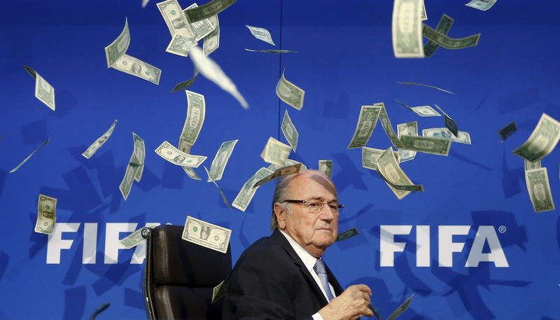 © Reuters. British comedian known as Lee Nelson (unseen) throws banknotes at FIFA President Blatter as he arrives for a news conference after the Extraordinary FIFA Executive Committee Meeting at the FIFA headquarters in Zurich