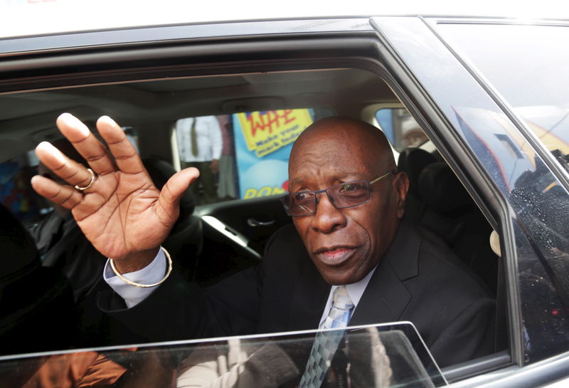 © Reuters. Former FIFA vice-president Jack Warner waves from a car after leaving a court where he is fighting against extradition to the U.S., in Port-of-Spain