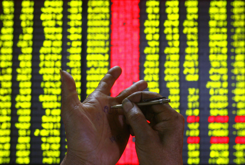 © Reuters. An investor makes a note on his hand at a stock exchange market in Kunming