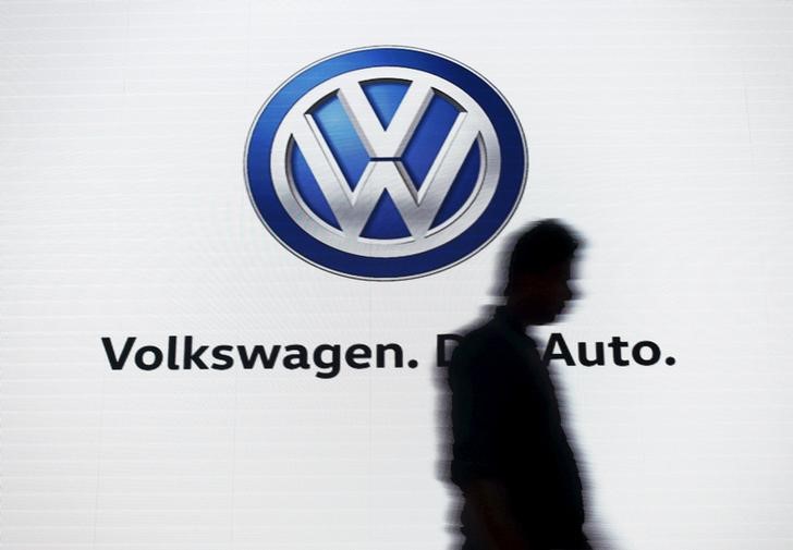 © Reuters. A man walks past a screen displaying a logo of Volkswagen at an event in New Delhi