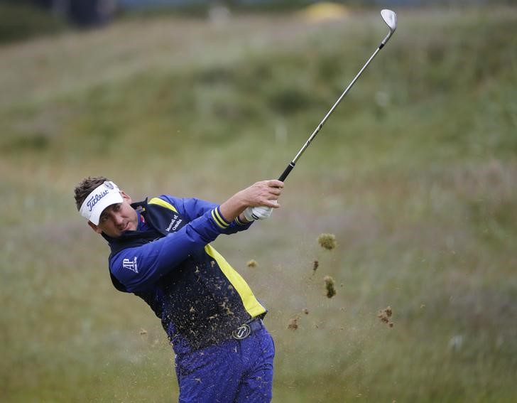 © Reuters. Poulter of England hits from the rough on the 14th hole during a practice round ahead of the British Open golf championship on the Old Course in St. Andrews, Scotland