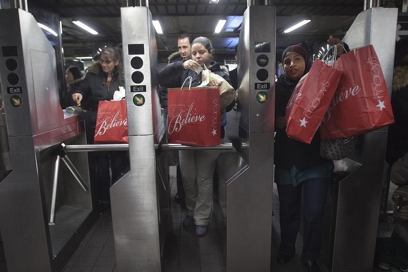 © Reuters. Shoppers enter the 34th Street subway station with packages on Black Friday in New York