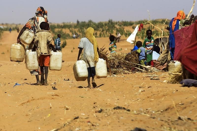 © Reuters. People walk to fill water containers at the Zamzam IDP camp in North Darfur