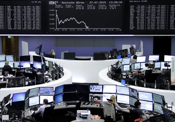 © Reuters. Traders are pictured at their desks in front of the DAX board at the Frankfurt stock exchange
