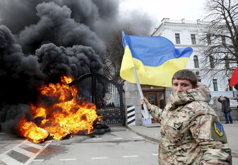 © Reuters. File photo of serviceman from Aydar battalion waving Ukrainian flag during protest in front of Ukraine's Defence Ministry in Kiev