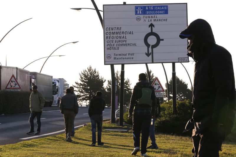 © Reuters. Imigrantes andando pelo túnel do Canal da Mancha, em Calais