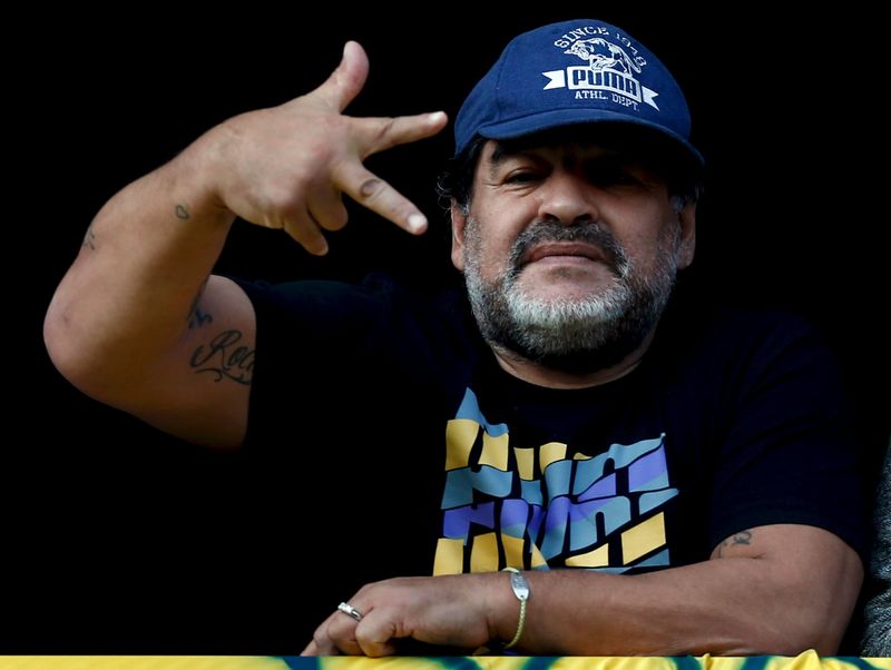 © Reuters. Former Argentine soccer player Maradona gestures from a balcony as he attends the Argentine First Division soccer match between Boca Juniors and Quilmes in Buenos Aires