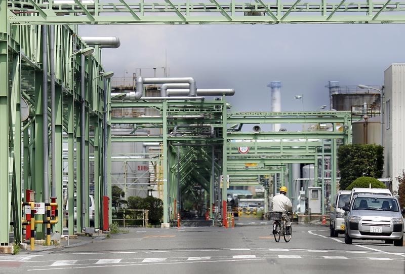 © Reuters. A worker cycles at a factory in Yokohama