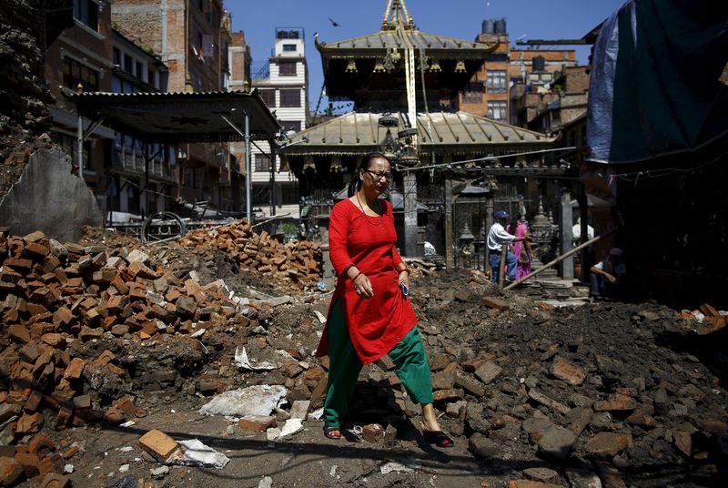 © Reuters. Mulher em meio a destroços de um templo, meses após os terremotos em Katmandu